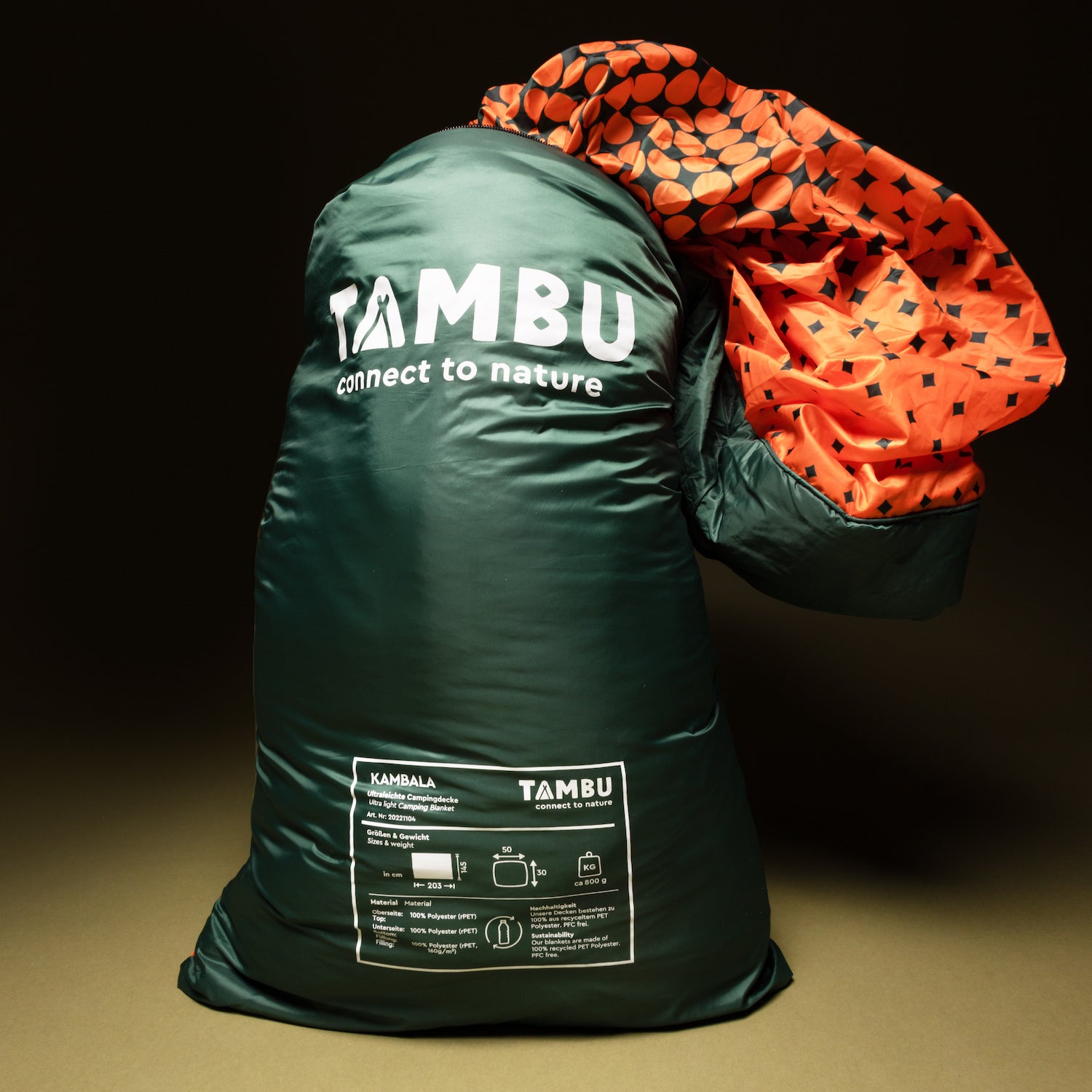 Ultraleichte Campingdecke KAMBALA von Tambu Outdoor in grünem Packsack mit weißem Logo und orange-schwarzem Innenmuster