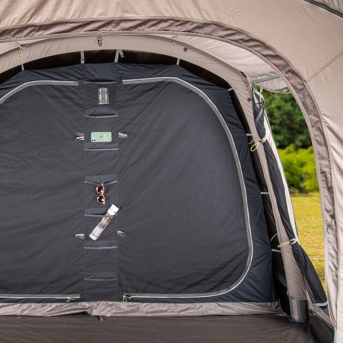 Innenansicht des BISALA 4 Familien Tunnelzelts von Tambu Outdoor mit grauem Innenzelt und Organizer mit Taschen für Handy, Sonnenbrille und Flasche
