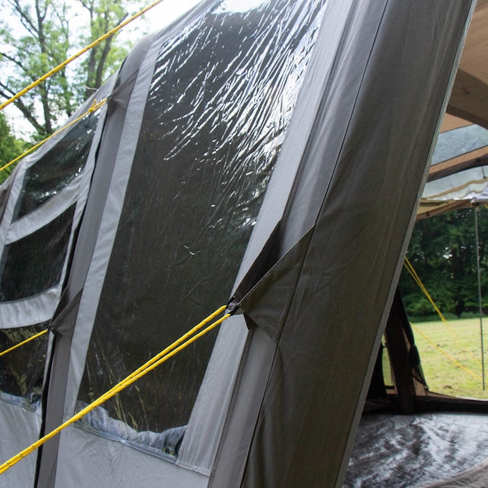 Nahaufnahme des beigen BISALA 5 Familien Tunnelzelts von Tambu Outdoor mit transparenten Fenstern und gelben Abspannleinen