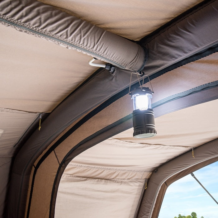 Innenansicht des BISALA 5 Familien Tunnelzelts von Tambu Outdoor mit aufgehängter, eingeschalteter Campinglaterne an der Zeltdecke