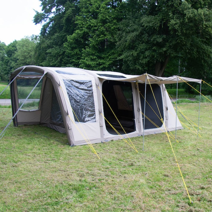 BISALA 5 Familien Tunnelzelt AIR von Tambu Outdoor in Beige mit großen Fenstern und zwei Eingängen auf einer Wiese vor Bäumen