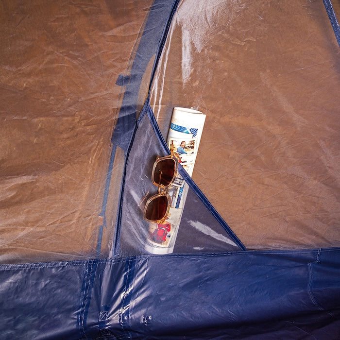 Innenansicht des KUTIR 2.0 Leichtgewichts-Trekkingzelts von Tambu Outdoor mit einer Netztasche, die eine Sonnenbrille und eine zusammengerollte Broschüre enthält