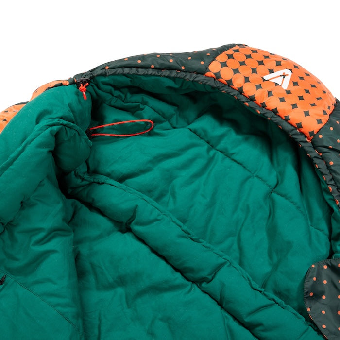 Grüner Innenraum des KARA 1000 oder 1600 Mumienschlafsacks von Tambu Outdoor mit orange-schwarzem, gepunktetem Rand und Zugband