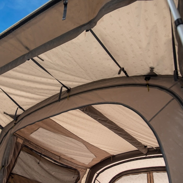 Innenansicht des BISALA VAN Busvorzelts AIR von Tambu Outdoor mit beige-braunem Stoff und stabilen Gestängebändern