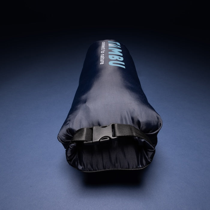 Dunkler Packsack mit Aufschrift 'TAMBU connect to nature' für den MOMI Mumienschlafsack 950 von Tambu Outdoor