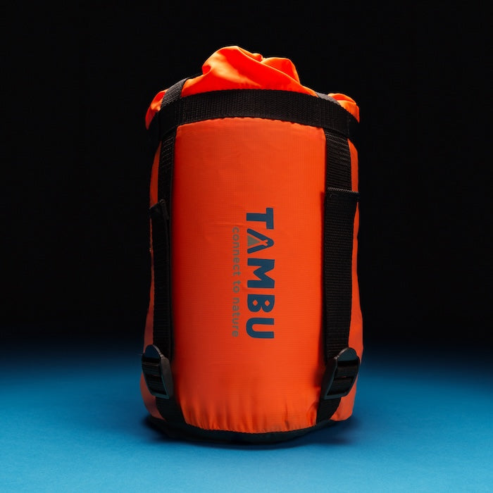 Oranger Packsack mit schwarzem Tragegurt und Aufschrift 'TAMBU' für OFRA 800 Mumienschlafsack von Tambu Outdoor