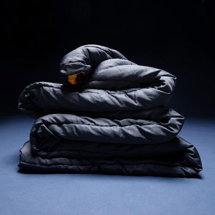 Gefalteter SAYAN Deckenschlafsack 1400 von Tambu Outdoor in dunklem Blau blauem Untergrund