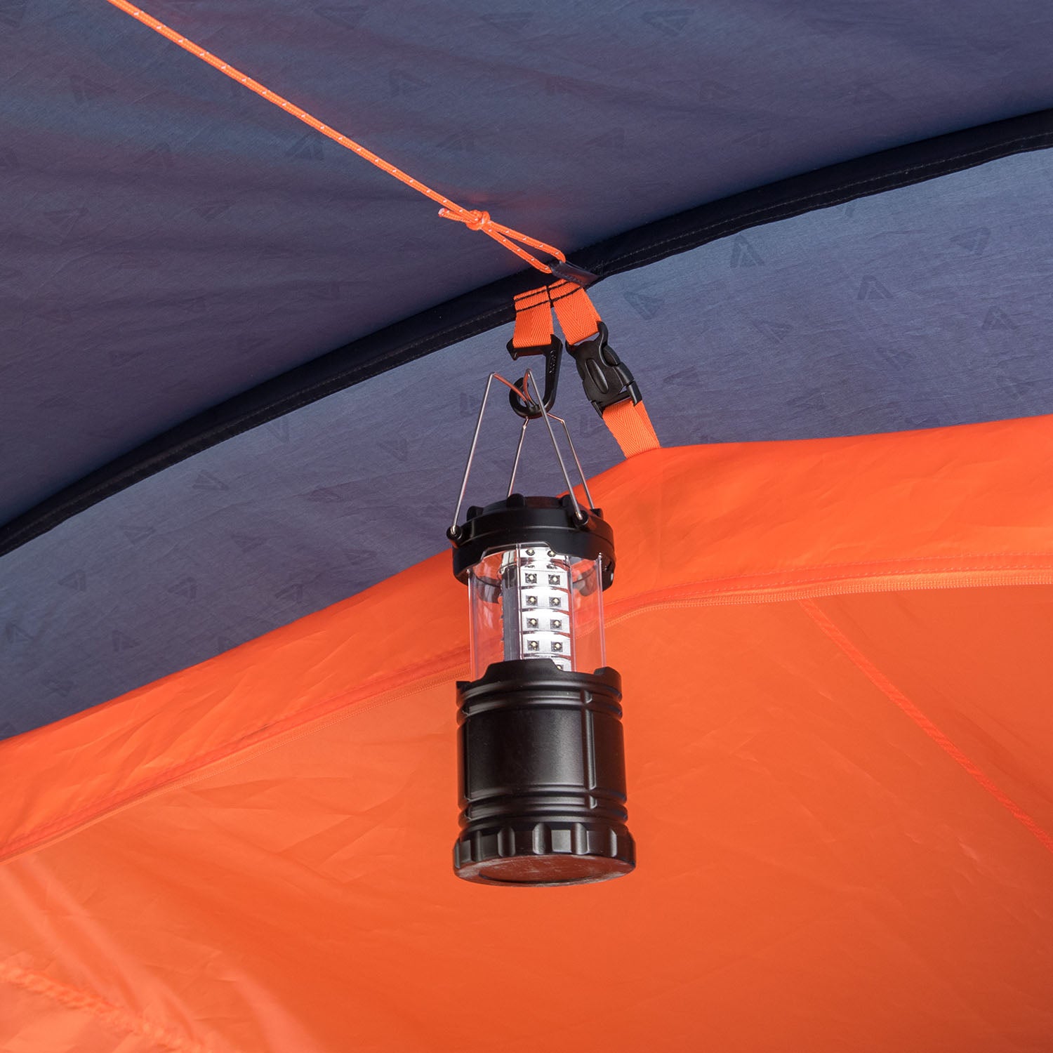 Schwarze Campinglaterne hängt an oranger Zeltdecke im Mandapa 4 Familienzelt von Tambu Outdoor