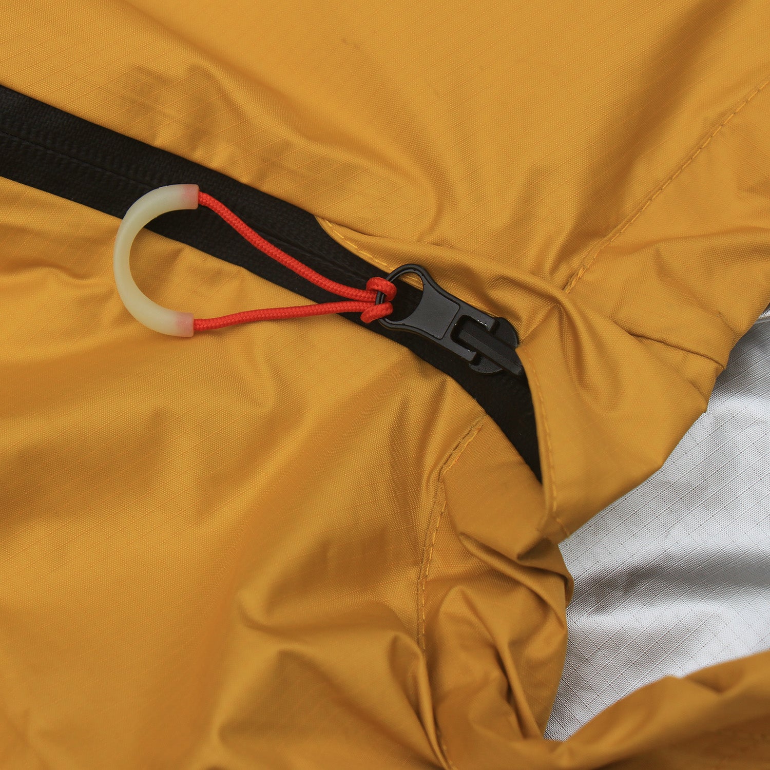 Gelber Biwacksack MARI 350 von Tambu Outdoor mit schwarzem Reißverschluss und rotem Zugband mit weißem Griff
