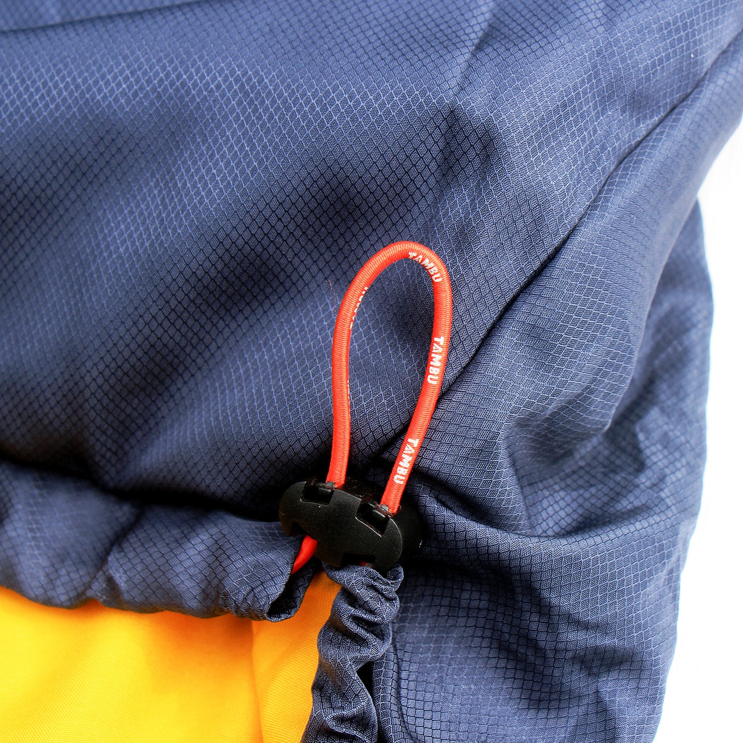 Detailaufnahme des dunkelblauen Mumienschlafsacks NEEL 750 von Tambu Outdoor mit rotem Kordelzug und schwarzem Stopper über gelbem Innenfutter