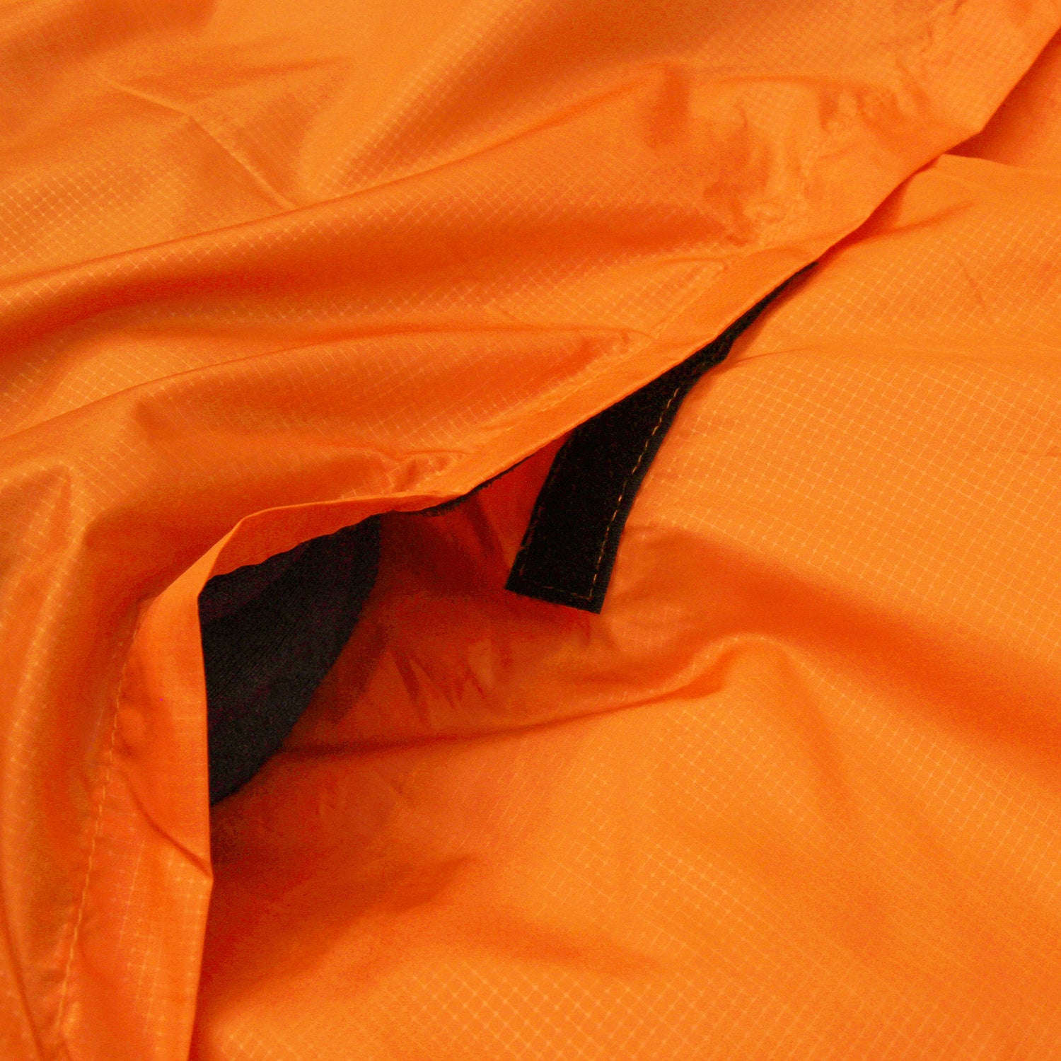 Nahaufnahme des orangen OFRA 800 Mumienschlafsacks von Tambu Outdoor mit sichtbarem schwarzen Klettverschluss